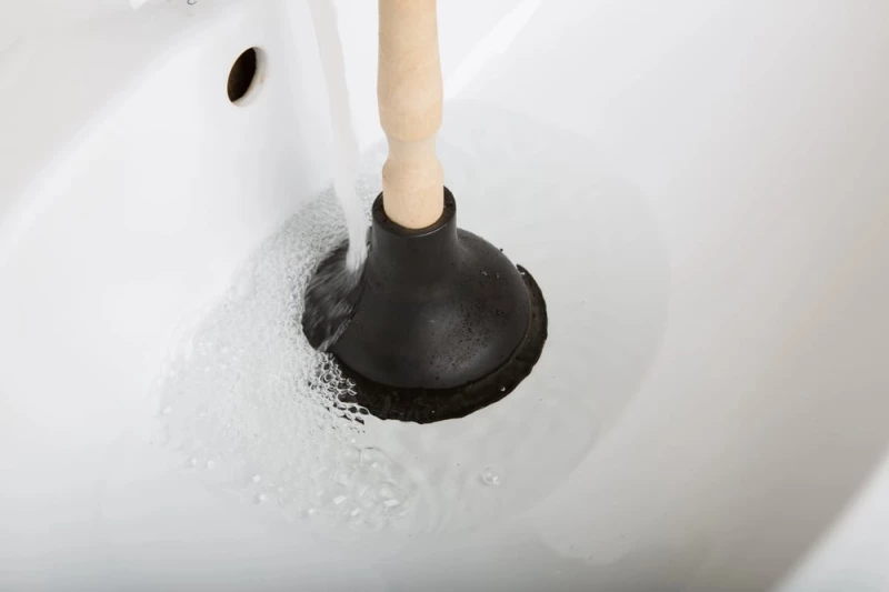 Clogged drain: Plumber unclogging a sink